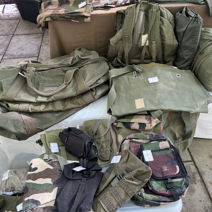 Équipement militaire occasion incluant des sacs à dos, sac de sport, sacoche bandoulière, rangers, chaussettes